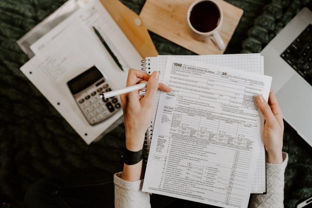 Business owner reviewing loan documents and running numbers before deciding whether to refinance