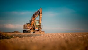 Yellow and black excavator on a worksite at golden hour, representing equipment financing
