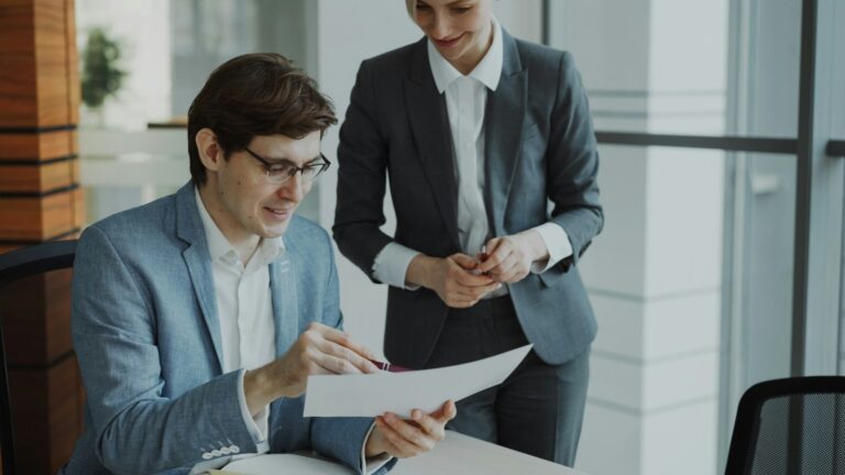 Two business professionals reviewing documents together at a table